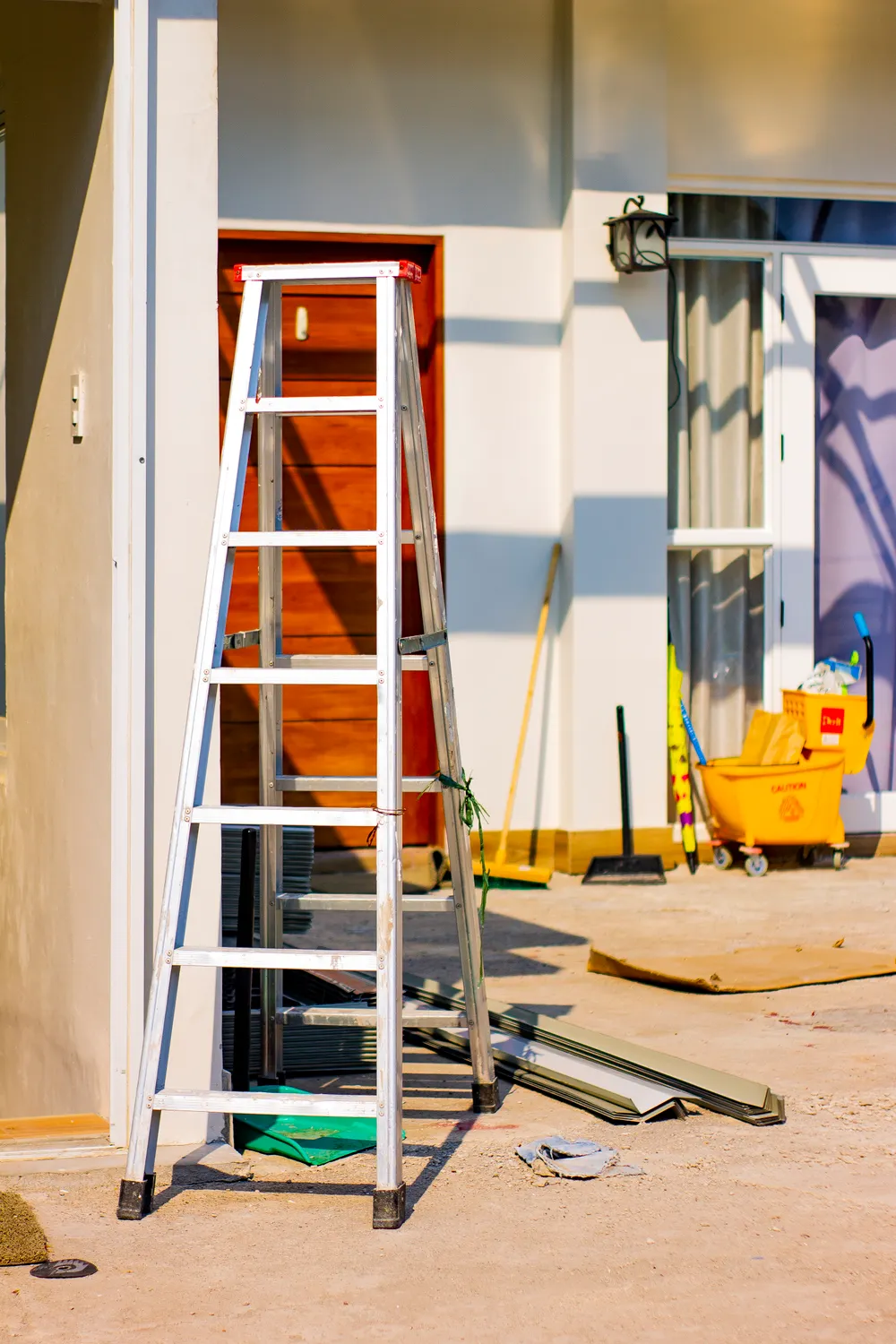 A ladder and tools outside a home during renovation.