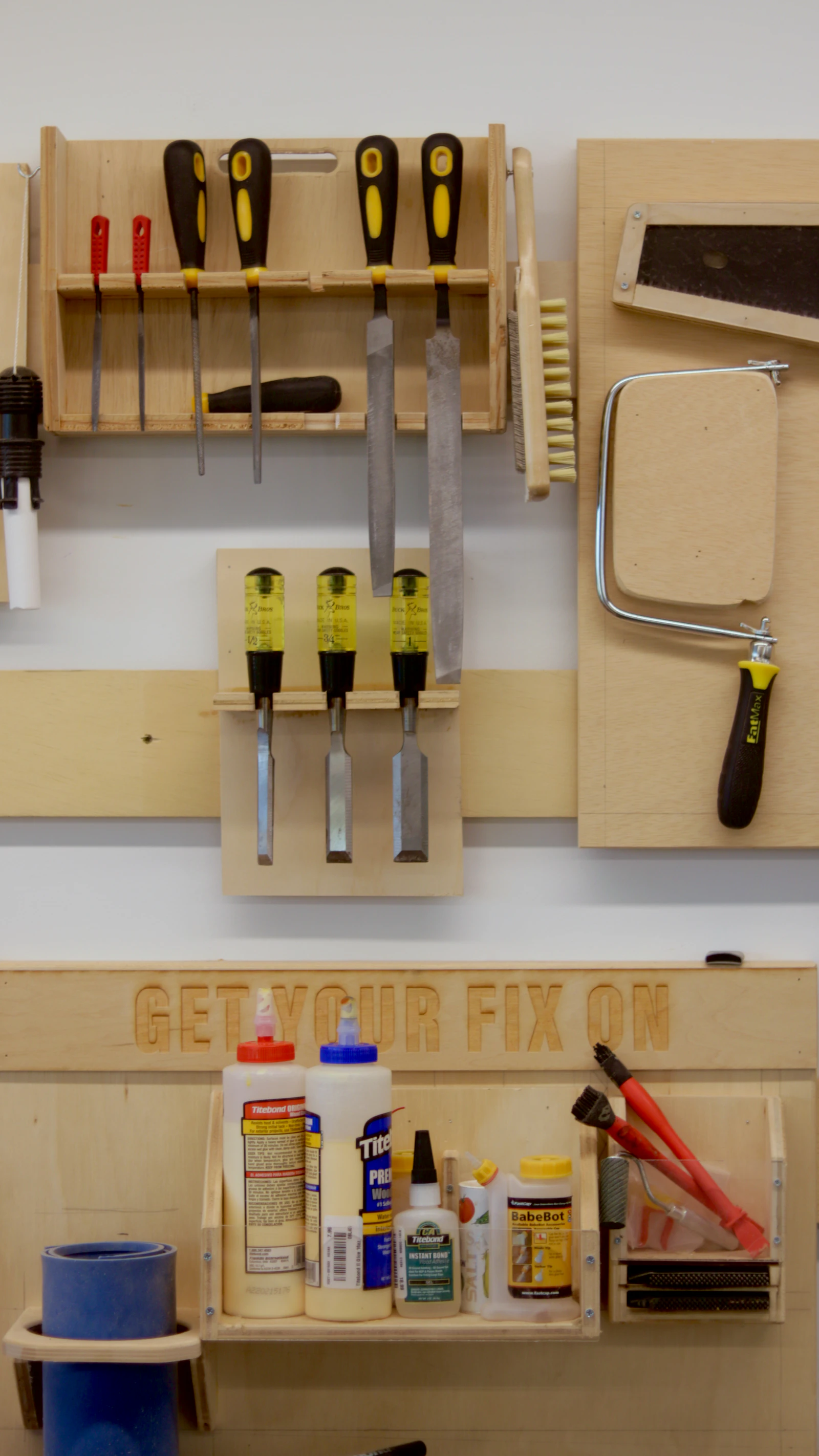 Files, chisels and saws organized on a wooden workshop wall.